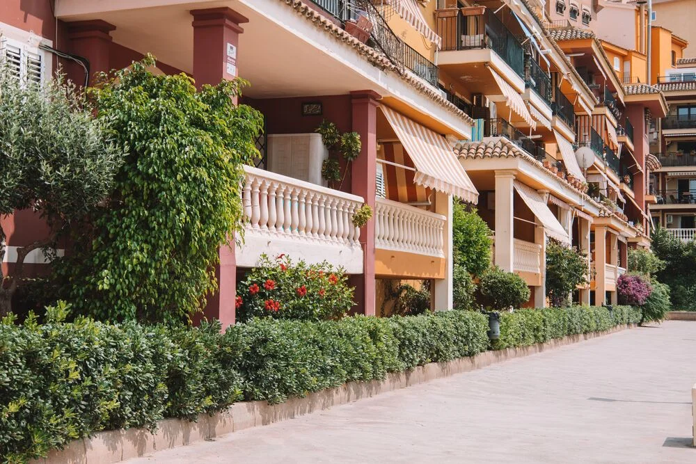 Urbanización residencial de estilo mediterráneo con amplias zonas verdes y piscina